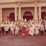 A photo taken with the Bishop, residents and the Sisters in front of the Chapel